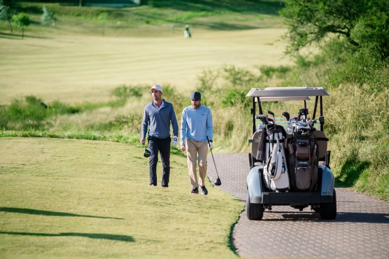 Jugadores de golf en Estancia El Terrón, Córdoba, junto a carrito y equipamiento